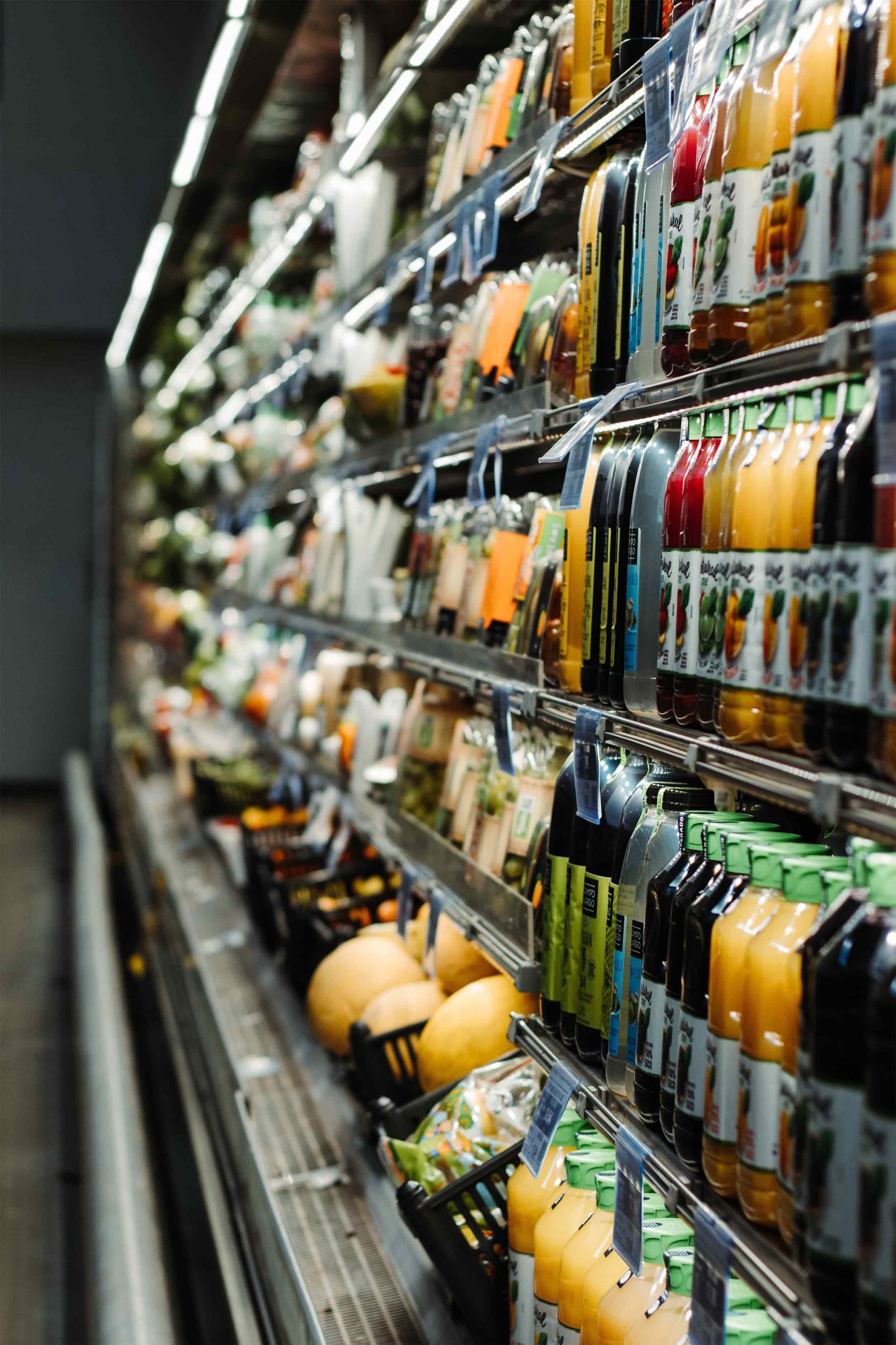 Close up of a supermarket fridge shelf full of fresh fruit jucices