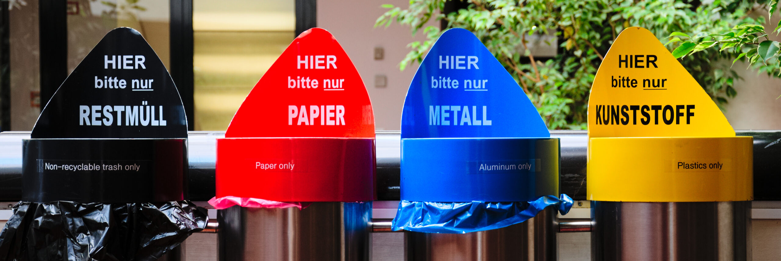 German street bins for recycling with colourful lids for non-recyclable waste, paper, aluminium and plastic.